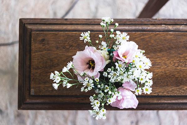 Pink and white flowers sitting on top of a coffin